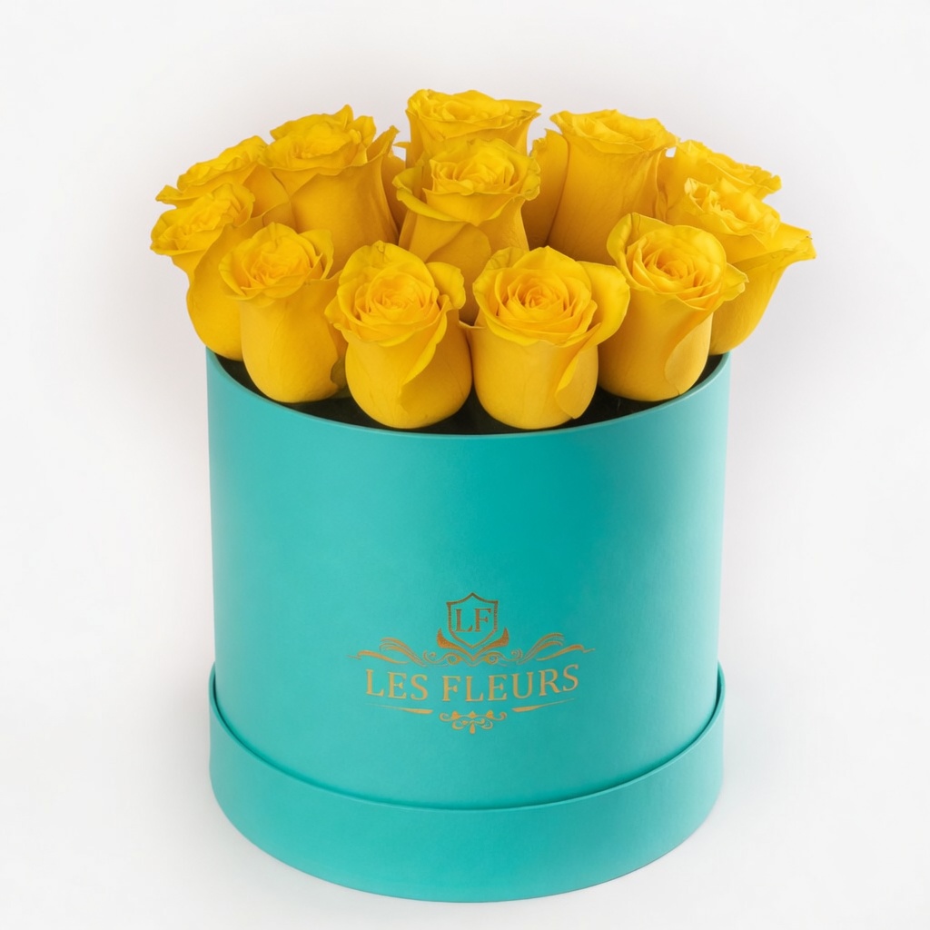Turquoise cylindrical hatbox filled with bright yellow roses, gold Les Fleurs logo on the box.